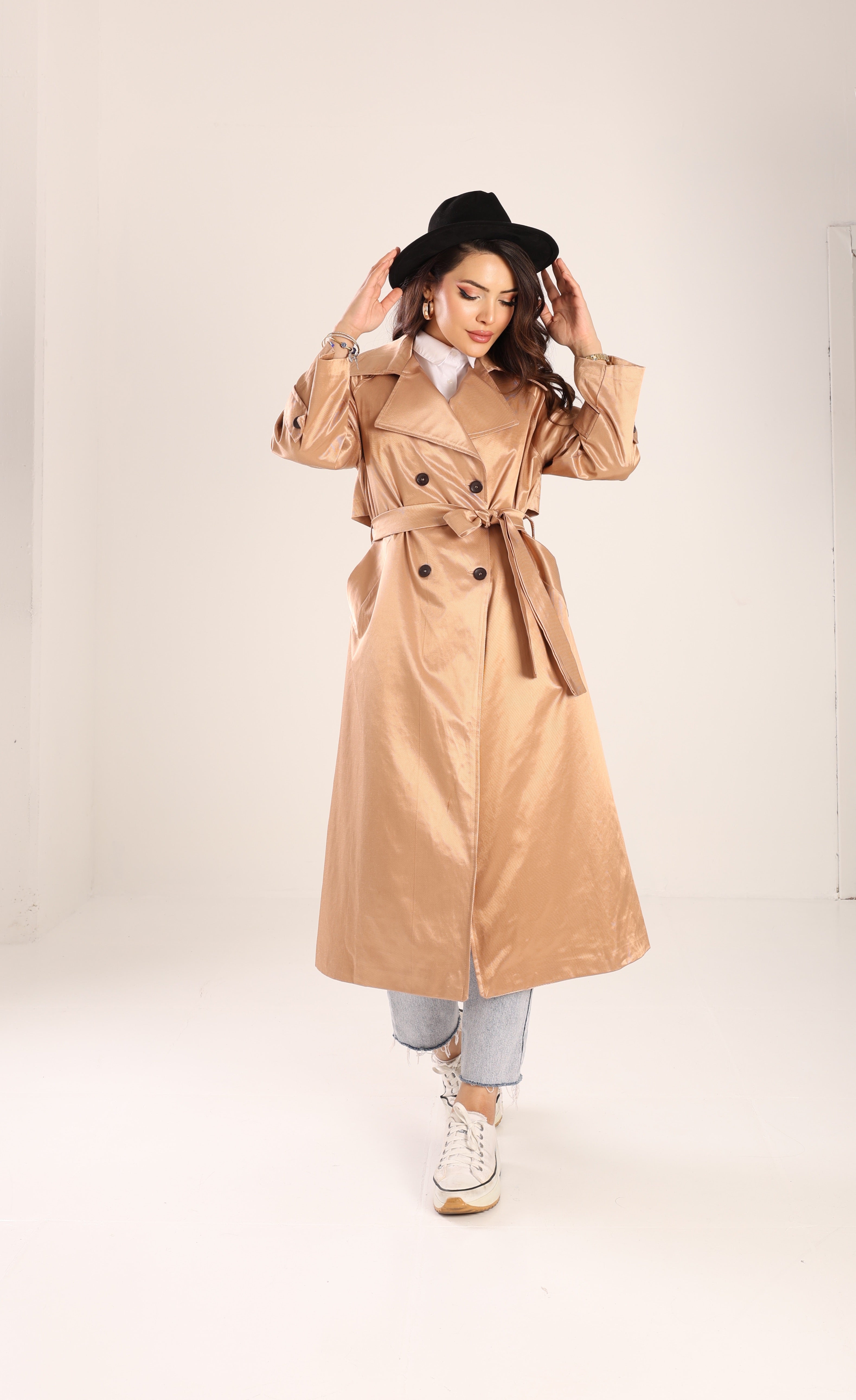Woman wearing a beige trench coat on a white background